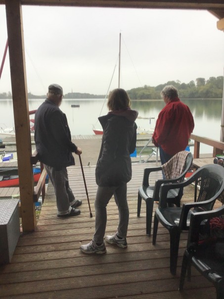 Drei Personen blicken auf den See