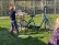 kleiner Junge steht vor einem Fahrrad mit drei Rädern
