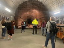 mehrere Personen von Hinten vor dem Tunnel des Eisenbahnschachts im Regierungsbunker