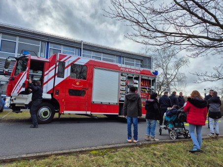 Schülergruppe und Feuerwehr steht vor Feuerwehrauto