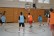Schüler in orangenen und blauen Hemdchen auf dem Spielfeld
