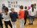 Schülergruppe von hinten vor einer weißen Wand stehend mit aufgehangenen Bildern des Künstlers random exp.