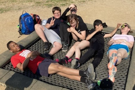 Schüler und Lehrer liegen auf einem Trampolin