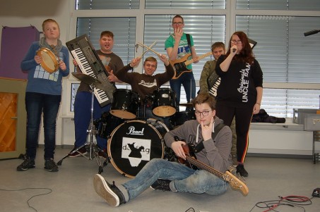 7 Schülerinnen und Schüler posieren mit ihren Instrumenten