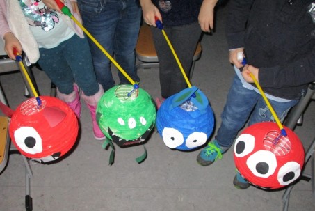 vier Kinder mit bunten Laternen