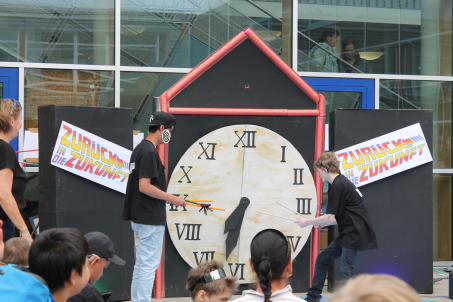 " Jungen stehen vor einer großen Uhr und der Aufschrift Zurück in die Zukunft
